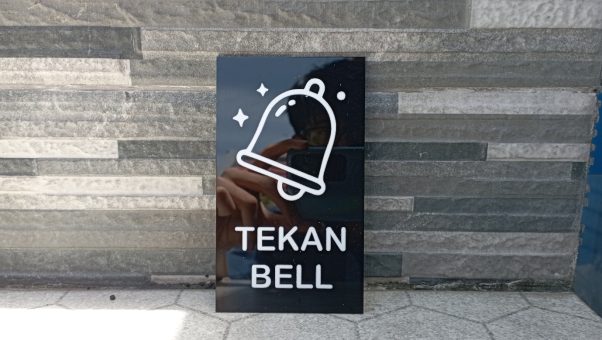 Akrilik sign tekan bell custom bening elegan di meja kasir.